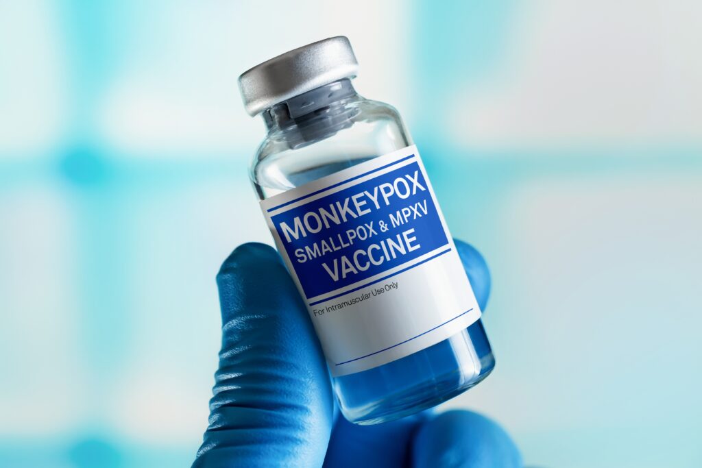 A hand holding a vial of Monkeypox Vaccine