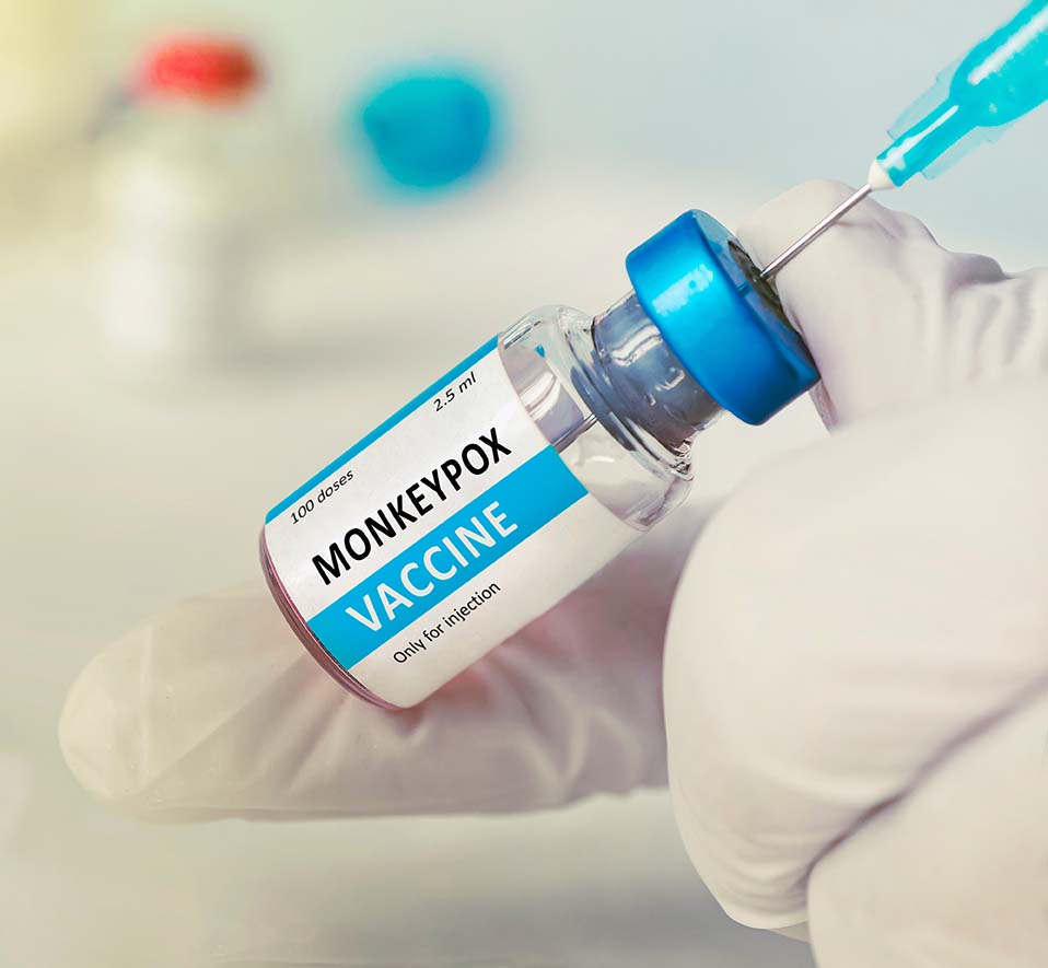 A hand holding a vial of the MonkeyPox Vaccine